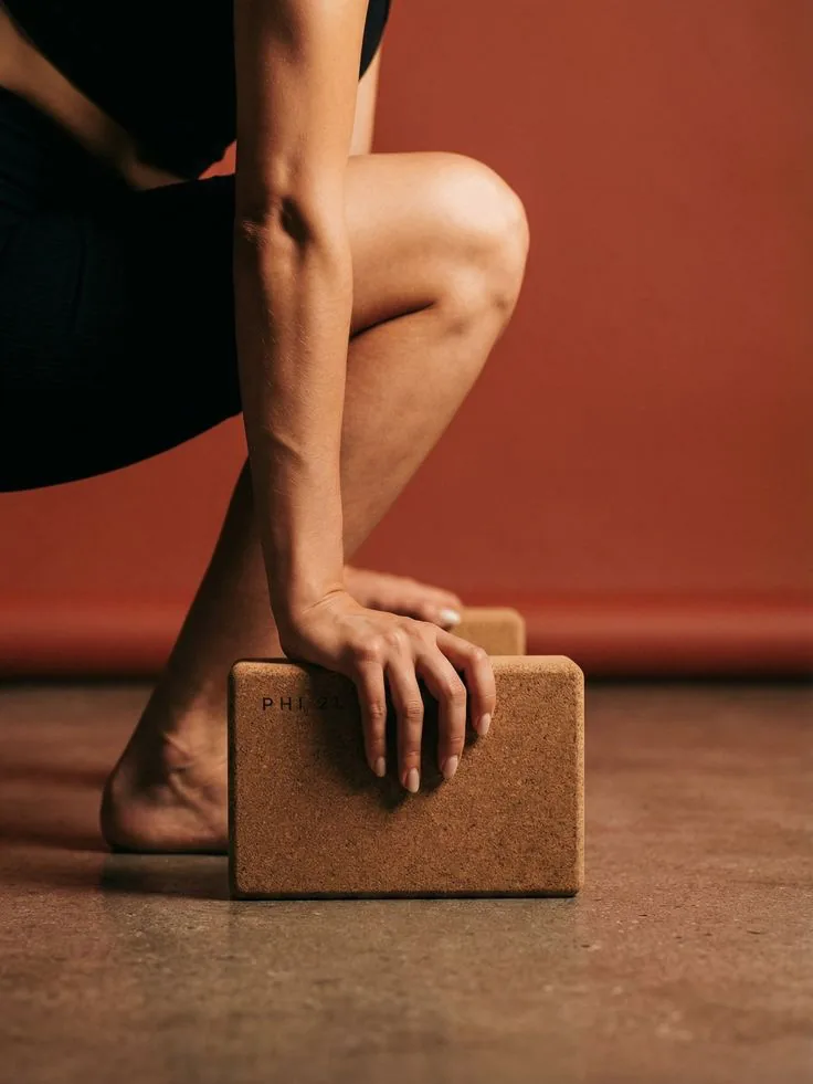 A hand resting on a cork yoga block